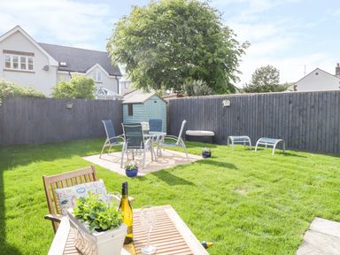 A garden with patio furniture and a small shed at Duck Cottage in Sutton Poyntz