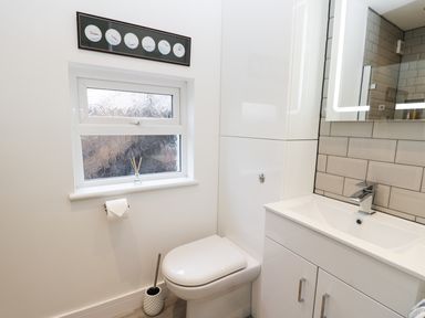 A bathroom with a toilet, sink, and frosted window at Sailors Lodge in Filey