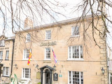 The exterior of a building with sun hotel sign and flags on the facade in warkworth