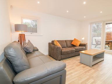 A living room with two sofas a coffee table and a lamp at Lily Cottage in Camelford