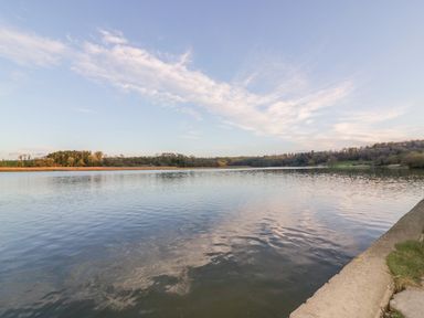 A body of water with trees and hills in the background at Chapel Pod in Callington