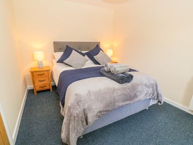 A bedroom with a double bed pillows bedside tables and lamps at The Old Cows House in Helston