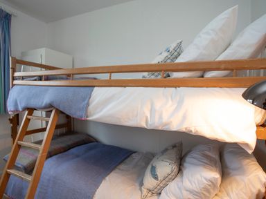 A bunk bed with pillows and blankets in a bedroom at Allt y Mor in Harlech
