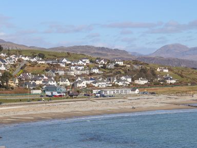 A coastal village with houses on hills near a beach and water at Bryn Deryn in Criccieth