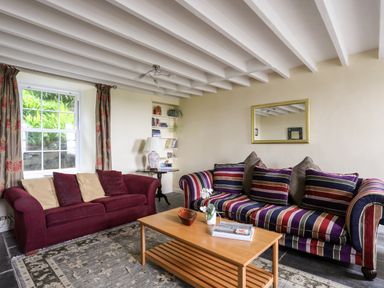 A sitting room with two sofas a wooden coffee table and a bookshelf at Bron Castell in Harlech
