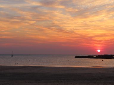 A beach scene with a sunset and boat at Curragho in Trearddur Bay
