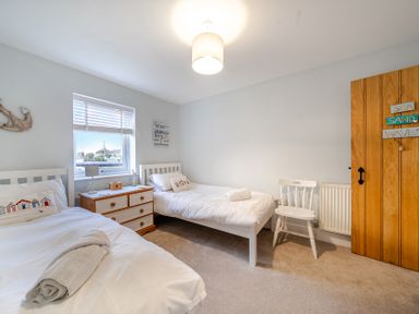 A bedroom with two beds and a window at Curragho in Trearddur Bay