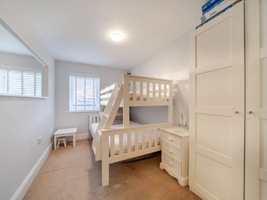 A bedroom with a bunk bed and wardrobe at Curragho in Trearddur Bay