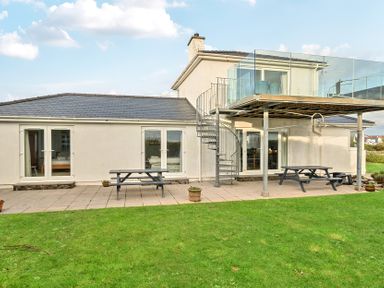 A building with a deck and stairs at Curragho in Trearddur Bay