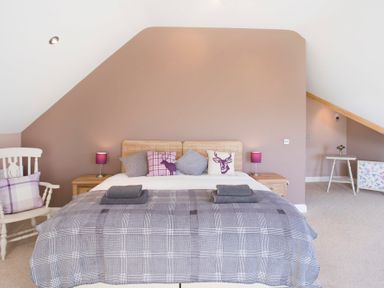 A bedroom with a double bed pillows and bedside tables with lamps at Dol Fraint in Star