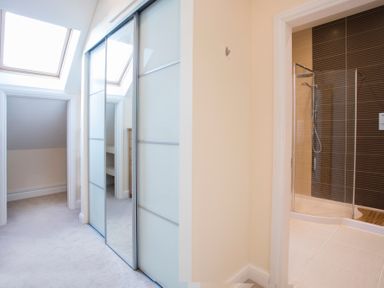 A hallway with a skylight and sliding closet doors next to a bathroom with a glass shower at Dol Fraint in Star