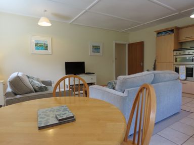 A living room with a sofa and television at Bryn Eira Tack Room in Llanfair PG