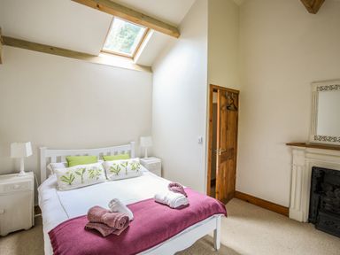 A bedroom with a bed and pillows under a skylight at Fron Fawr in Nefyn