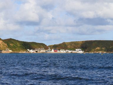 A coastal village with houses and hills by the sea at Fron Fawr in Nefyn