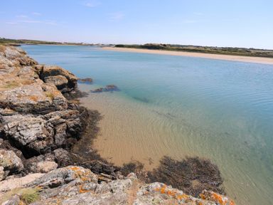 A coastal scene with rocks and clear water at Glanrhyd Uchaf in Llanfair yn Neubwll