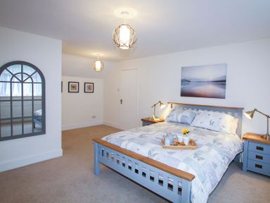 A bedroom with a double bed bedside tables and lamps at Gwyndy Bach in Beddgelert