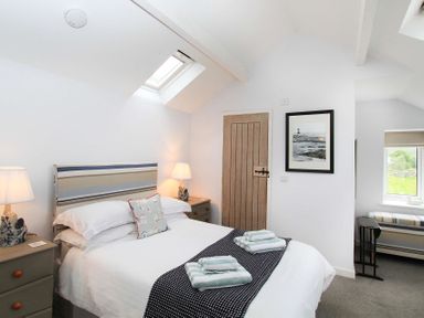 A bedroom with a double bed bedside tables lamps and a skylight at Big House in Llandecwyn