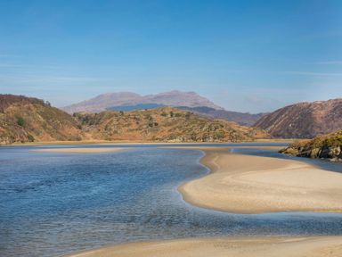 A river with sandbanks surrounded by hills under a clear sky at Big House in Llandecwyn