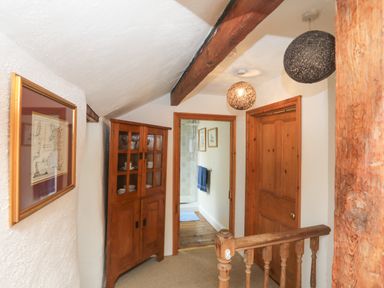 A hallway with wooden cabinet and doors leading to a bathroom at Llwyn Bedw in Nant Peris
