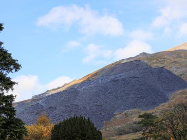 A hillside covered with slate rocks and trees at Llwyn Bedw in Nant Peris