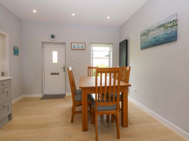 A dining area with a table and chairs at Menai Cottage in Brynsiencyn
