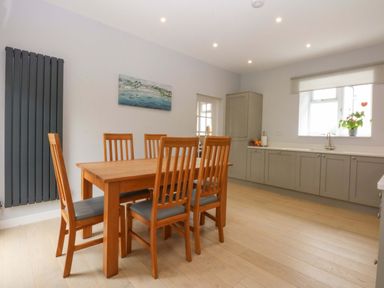 A kitchen with a dining table and chairs at Menai Cottage in Brynsiencyn