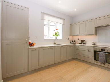 A kitchen with cabinets and a sink at Menai Cottage in Brynsiencyn