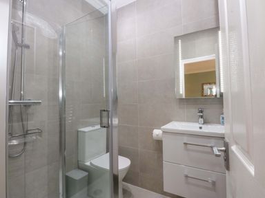 A bathroom with a shower and sink at Menai Cottage in Brynsiencyn