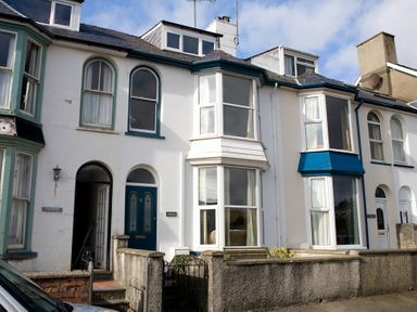 A row of terraced houses with bay windows and arched front doors at Morfin in Criccieth