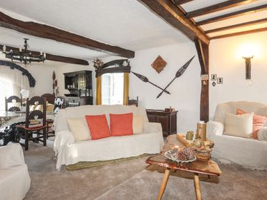 A living room with sofas and a wooden coffee table and a dining table with chairs at Morfa Lodge in Porthmadog