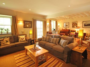 A living room with two sofas cushions coffee table and lamps at Perth Hwfa in Malltraeth