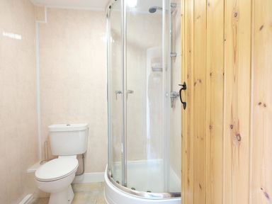A bathroom with a toilet and a glass shower enclosure at Pen Y Bont in Pontllyfni