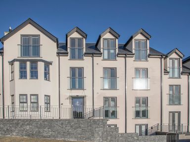 A multi-story residential building with multiple windows and balconies at The Pot Loft in Benllech
