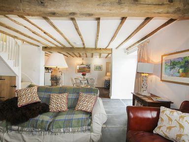 A living room with sofas pillows a lamp and a dining table with chairs at Ty Mawr Porthmadog in Porthmadog