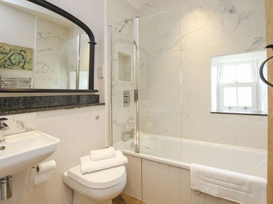 A bathroom with a toilet sink bathtub and a window at Ty Mawr Porthmadog in Porthmadog