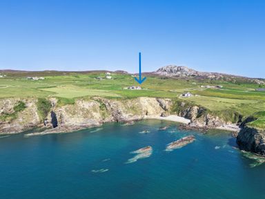 A coastline with cliffs and a house at Ty Nant in South Stack
