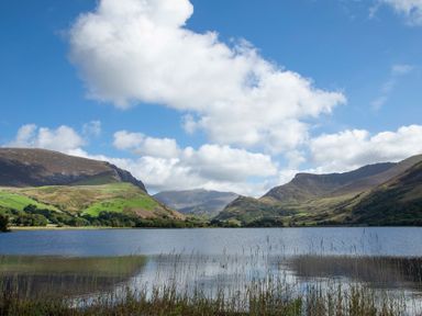 A lake surrounded by green hills under a blue sky with clouds at 17 Victoria Terrace - Perthi in Nantlle