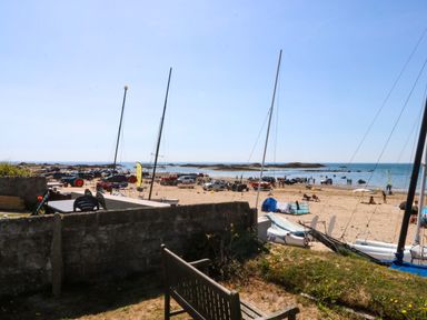 A beach with vehicles and people at Windygates in Rhosneigr