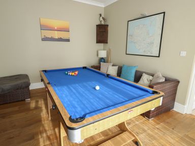 A game room with a pool table and wall art at West View in Rhosneigr