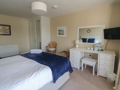 A bedroom with a bed and dresser at West View Rhosneigr