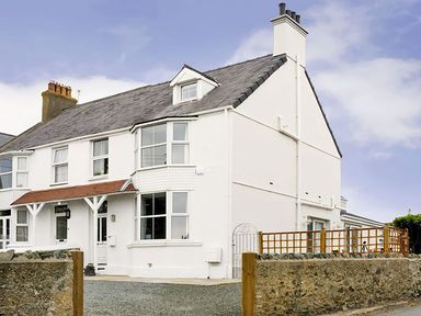 A house with a garden and fence at West View in Rhosneigr