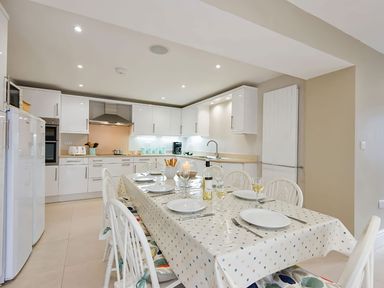 A kitchen with a dining table and chairs at West View in Rhosneigr