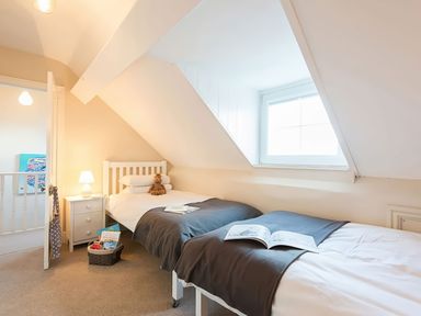 A bedroom with two beds and a window at West View in Rhosneigr