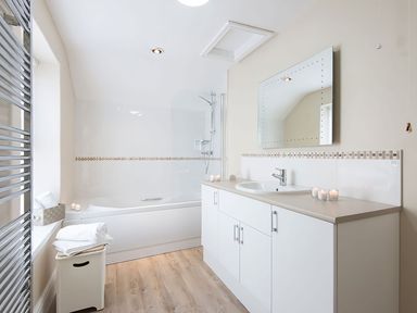 A bathroom with a bathtub and sink at West View in Rhosneigr