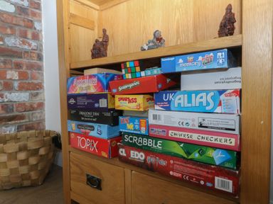 A bookshelf with board games and figurines at Llanallgo Church Rooms
