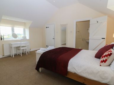 A bedroom with a bed and a table at Llanallgo Church Rooms