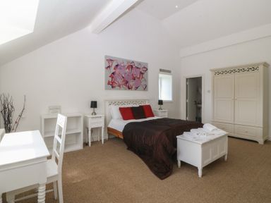 A bedroom with a bed and furniture at Llanallgo Church Rooms