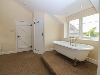 A bathroom with a bathtub and window at Llanallgo Church Rooms 