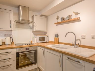 A kitchen with a stove oven microwave sink and countertop at Potters by the Sea in Sennen