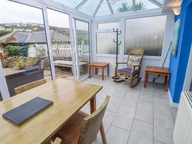 A conservatory with a table and chairs at Pebble Cottage Portreath